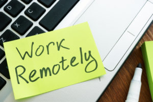 work remotely on a post it note that is on a laptop